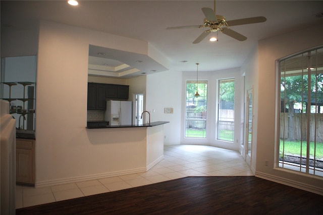 kitchen with plenty of natural light, ceiling fan, white refrigerator with ice dispenser, and light wood-type flooring