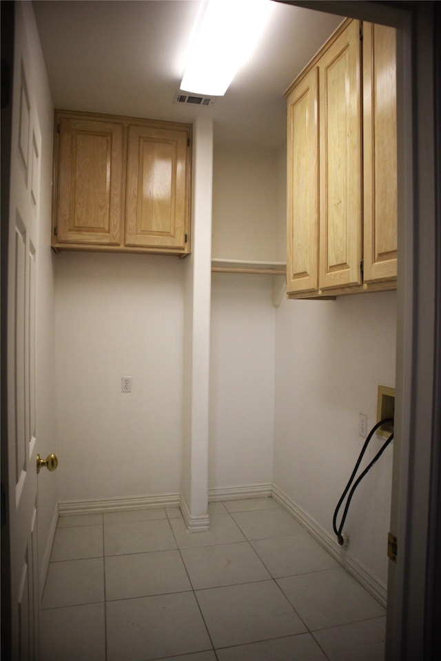 laundry area with tile floors, cabinets, and washer hookup