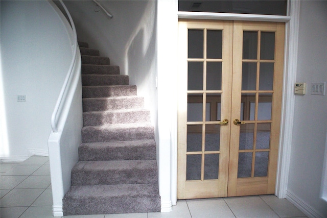 stairs featuring tile flooring and french doors