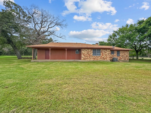 rear view of property with a yard and central AC unit