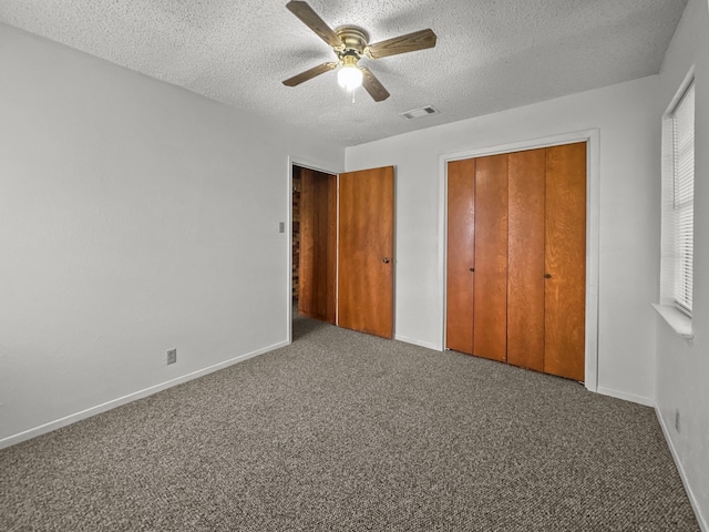 unfurnished bedroom featuring ceiling fan, carpet floors, a textured ceiling, and a closet