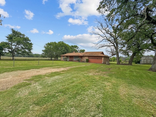 view of yard with a rural view and a garage