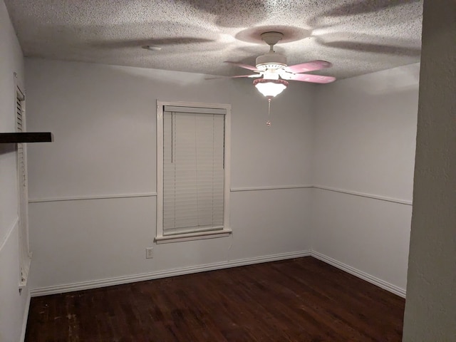 empty room featuring ceiling fan, dark hardwood / wood-style flooring, and a textured ceiling