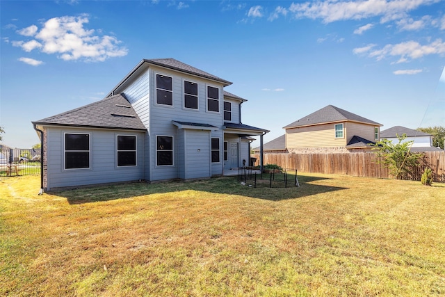 rear view of property with a lawn