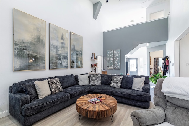 living room featuring a high ceiling and light hardwood / wood-style flooring