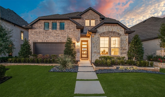 view of front of home with a garage and a yard