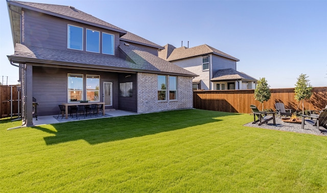 back of house featuring a patio, a yard, and an outdoor fire pit