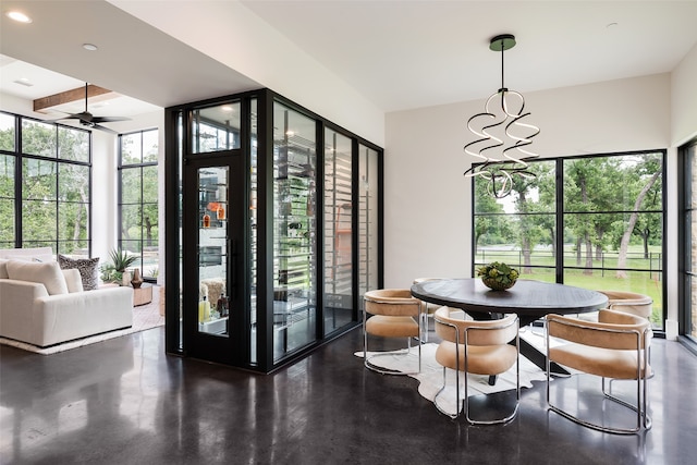 interior space featuring beamed ceiling and ceiling fan with notable chandelier