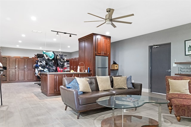 living room with rail lighting, ceiling fan, and sink