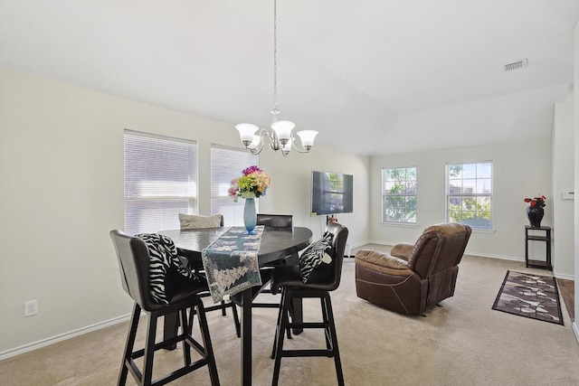 dining space with light colored carpet and a notable chandelier