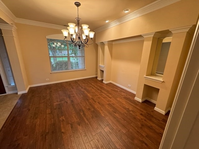 unfurnished dining area with ornamental molding, decorative columns, an inviting chandelier, and wood-type flooring