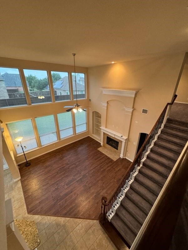 unfurnished living room with wood-type flooring and ceiling fan