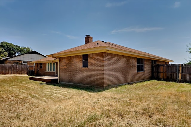 rear view of property featuring a lawn