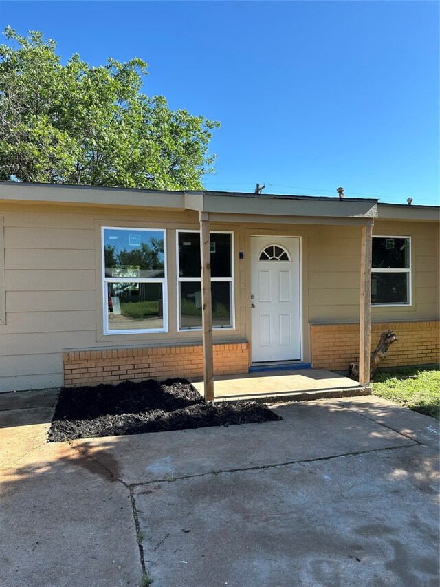 view of exterior entry with a patio