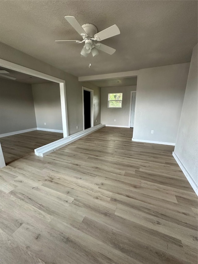 spare room featuring a textured ceiling, ceiling fan, and wood-type flooring