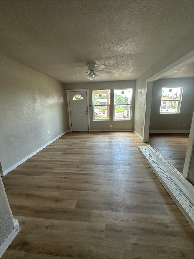 foyer entrance featuring ceiling fan, a textured ceiling, and dark hardwood / wood-style floors