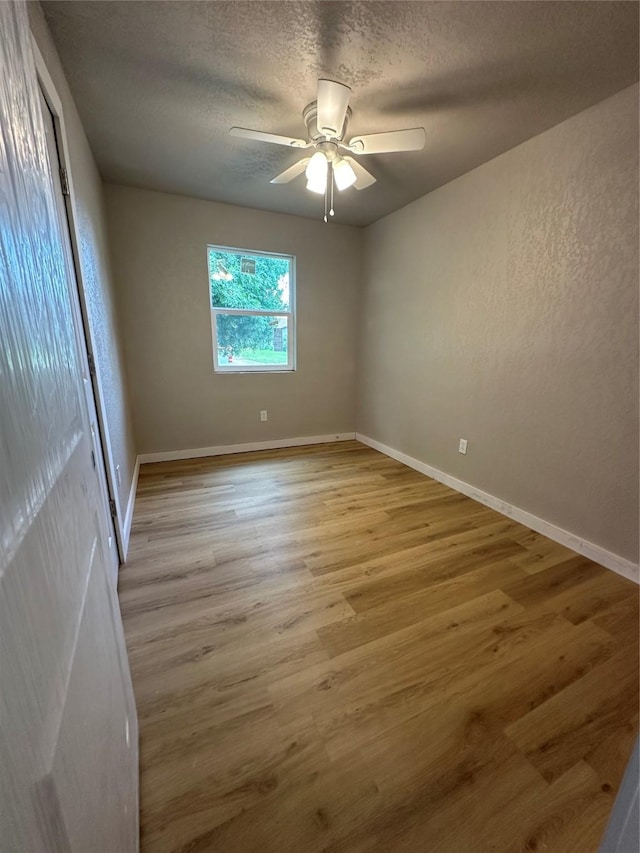 spare room featuring a textured ceiling, ceiling fan, and light hardwood / wood-style flooring