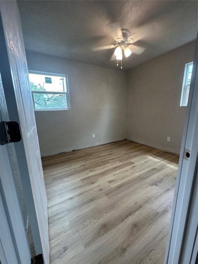 empty room featuring light wood-type flooring and ceiling fan