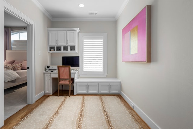 interior space featuring ornamental molding and light hardwood / wood-style floors