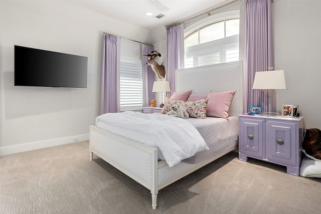 carpeted bedroom with ceiling fan and multiple windows