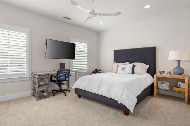 carpeted bedroom with ceiling fan and multiple windows