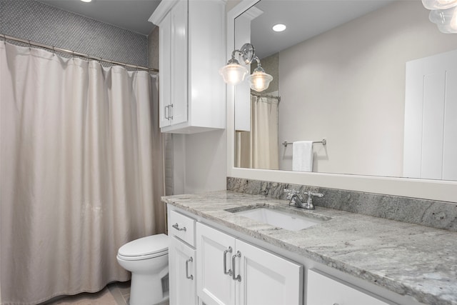 bathroom with vanity with extensive cabinet space, toilet, and tile floors