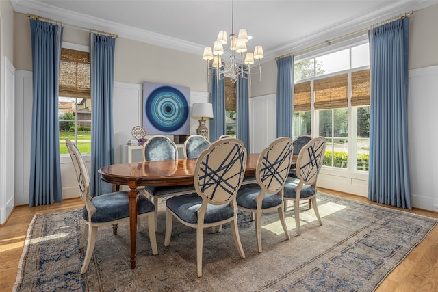 dining space featuring a healthy amount of sunlight, light wood-type flooring, and a notable chandelier