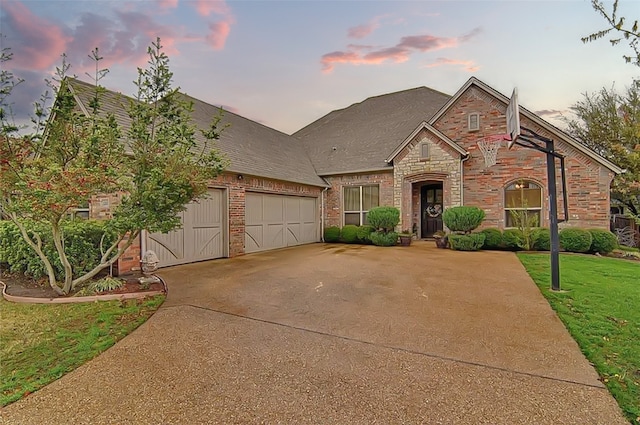 view of front of house with a garage and a lawn