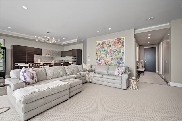 carpeted living room with an inviting chandelier