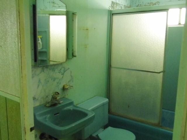 bathroom featuring sink, toilet, and walk in shower