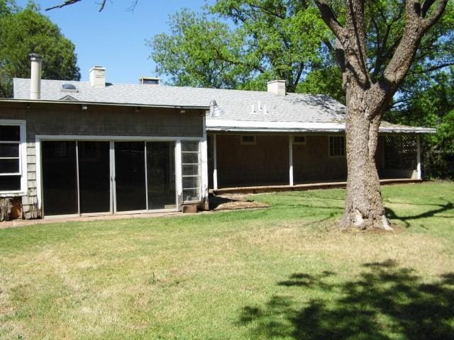 rear view of property with a yard