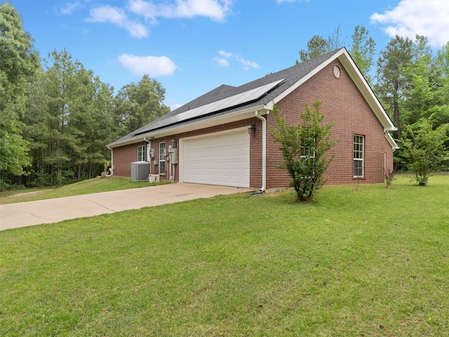 ranch-style house featuring a front yard, cooling unit, a garage, and solar panels