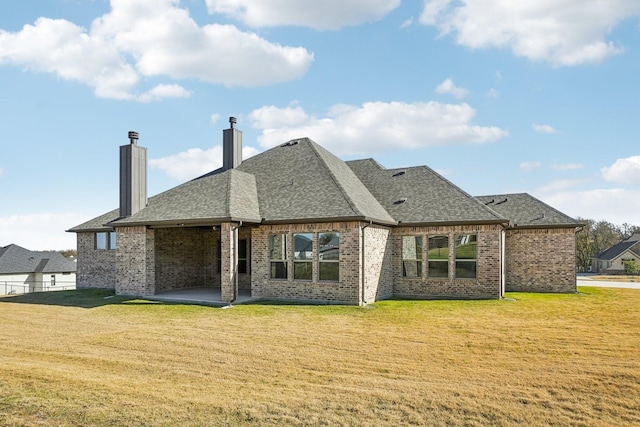 back of house featuring a patio and a yard