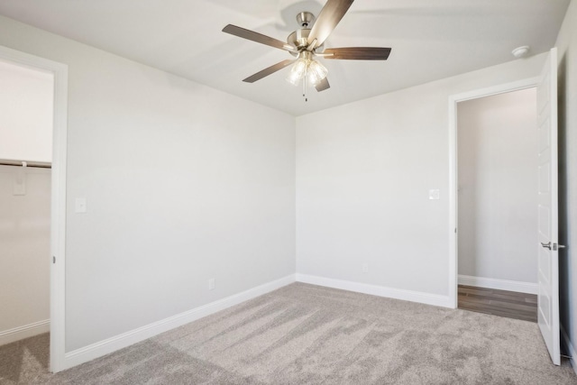 unfurnished bedroom with ceiling fan, carpet, a spacious closet, and a closet