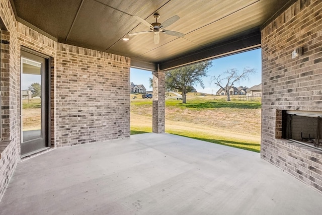 view of patio / terrace featuring ceiling fan and an outdoor brick fireplace