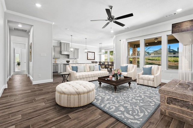 living room featuring ceiling fan, a wealth of natural light, and crown molding