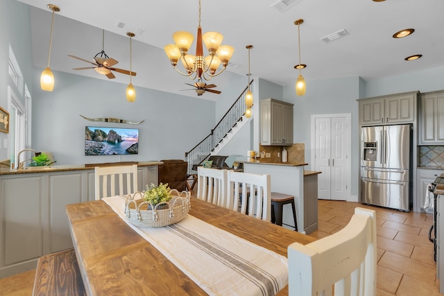 dining room with sink, light tile flooring, and ceiling fan with notable chandelier