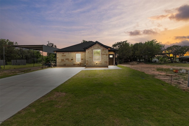 view of front of house with stone siding and a yard