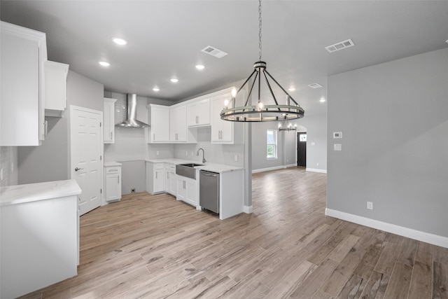 kitchen with white cabinets, dishwasher, wall chimney exhaust hood, and sink