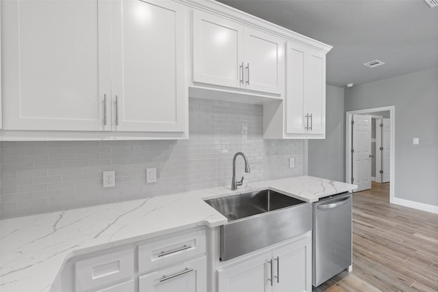 kitchen featuring light stone countertops, dishwasher, sink, decorative backsplash, and white cabinets