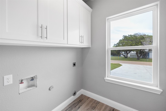 clothes washing area featuring hookup for an electric dryer, cabinets, washer hookup, gas dryer hookup, and hardwood / wood-style floors