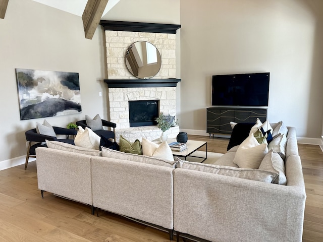 living room featuring hardwood / wood-style flooring, a fireplace, and beam ceiling