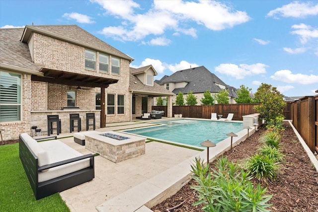 view of swimming pool featuring exterior bar, a patio area, and an outdoor living space with a fire pit