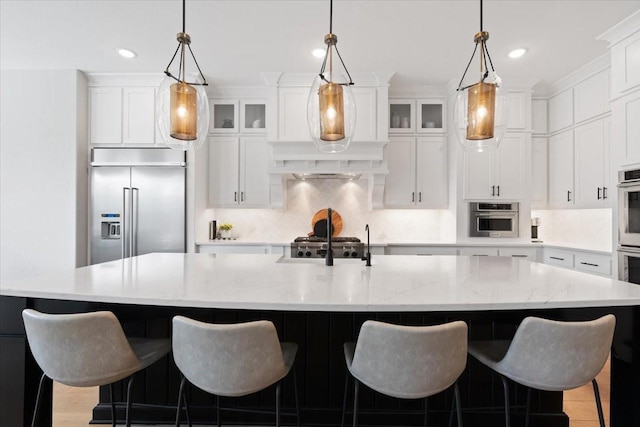 kitchen featuring a large island, pendant lighting, white cabinetry, backsplash, and stainless steel appliances