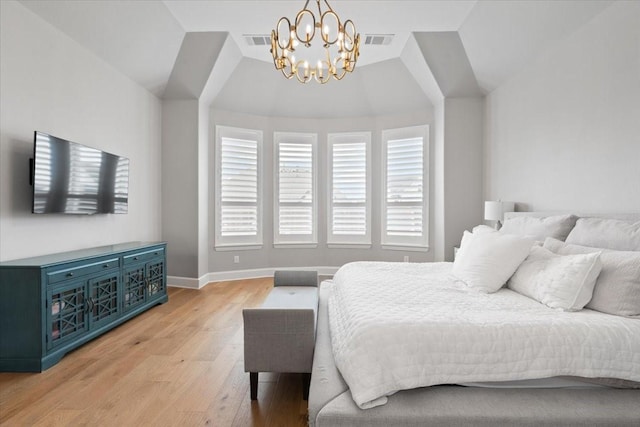 bedroom featuring lofted ceiling, a notable chandelier, and light hardwood / wood-style flooring