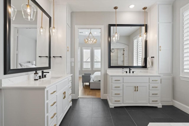 bathroom featuring vanity, tile patterned floors, a healthy amount of sunlight, and an inviting chandelier