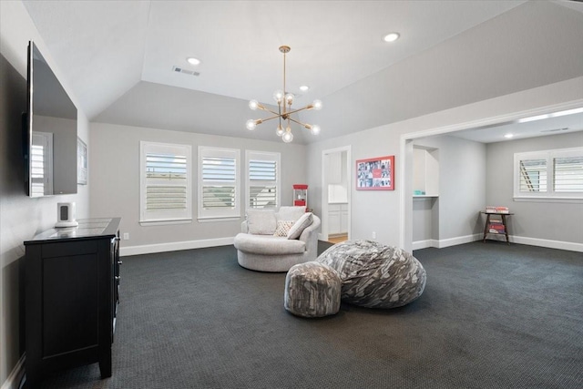 living area featuring lofted ceiling, dark carpet, a healthy amount of sunlight, and an inviting chandelier