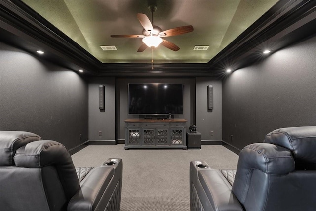 carpeted home theater with crown molding, ceiling fan, a raised ceiling, and vaulted ceiling