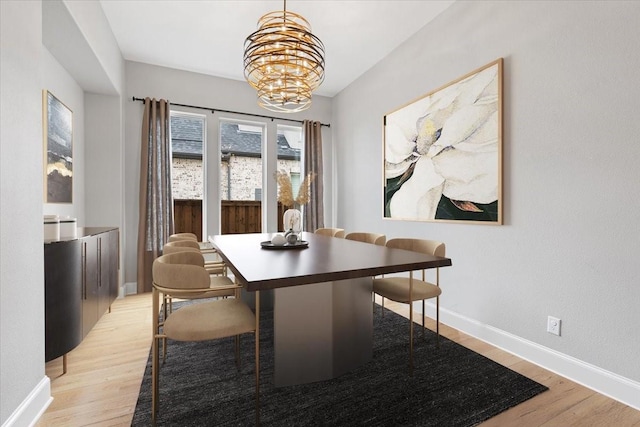 dining area featuring an inviting chandelier and light hardwood / wood-style flooring