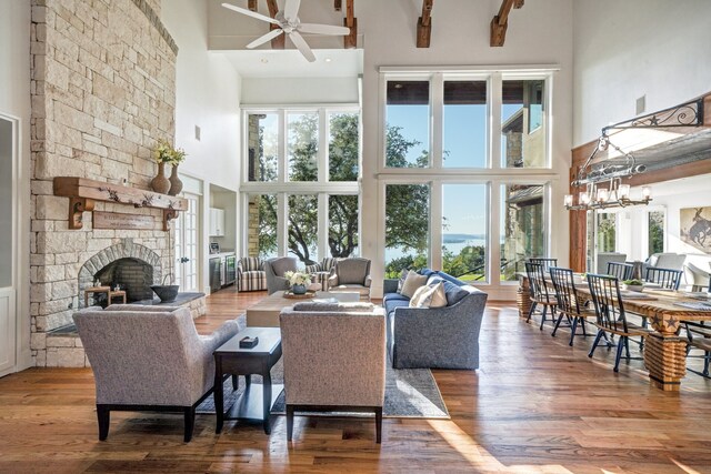 living room with a fireplace, a towering ceiling, and hardwood / wood-style floors